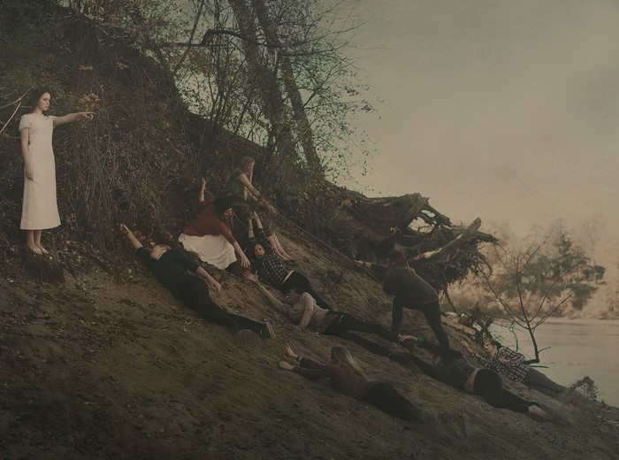 Group of people on a muddy bank by a river