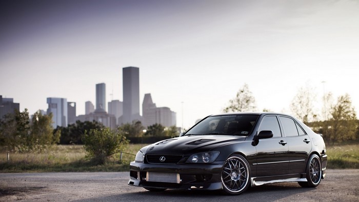 Black Lexus IS sedan with Houston skyline