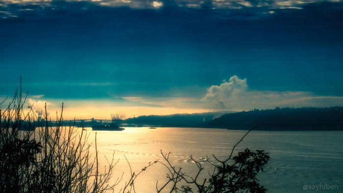 Waterway with Industrial Harbor and Distant Mountain at Sunset