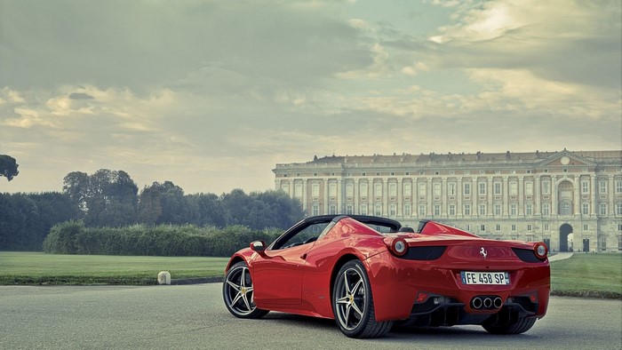 Red Ferrari 458 Spider parked in front of a palace