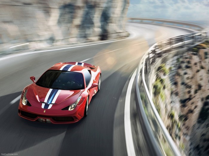 Red Ferrari 458 Speciale driving on a winding road