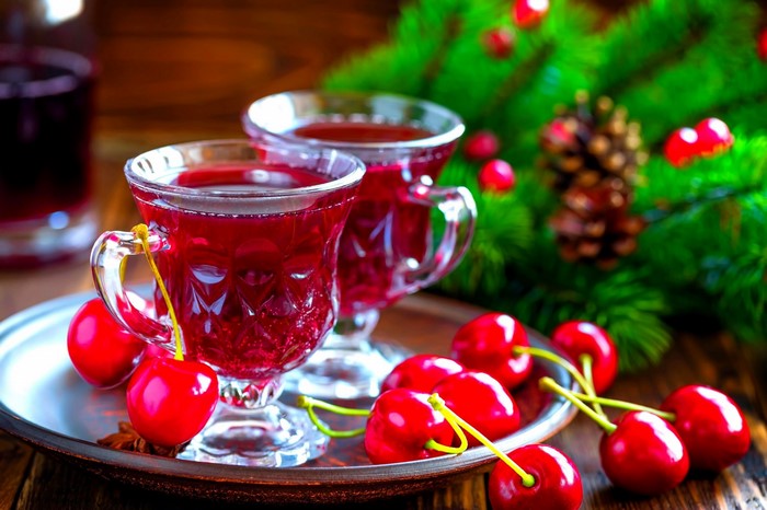 Two glasses of red drink with cherries and Christmas decor