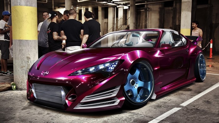 Customized magenta sports car with blue wheels in a parking garage