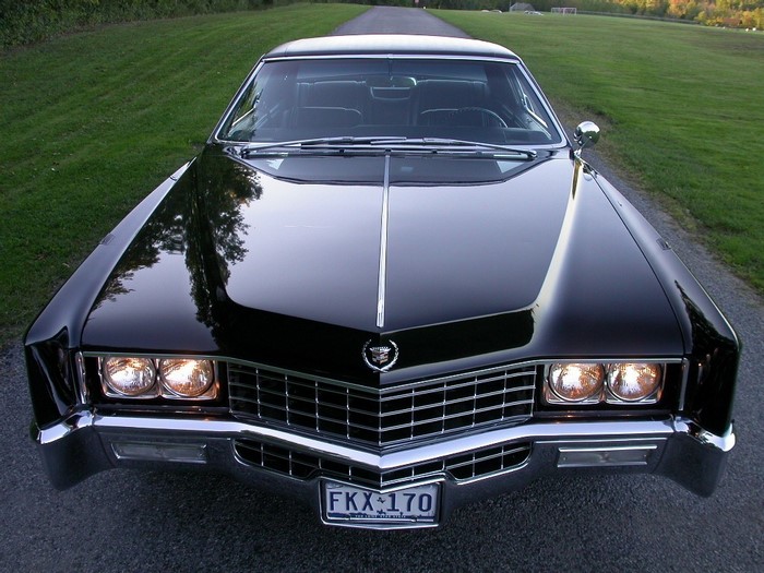 Black Cadillac Coupe de Ville parked on a road