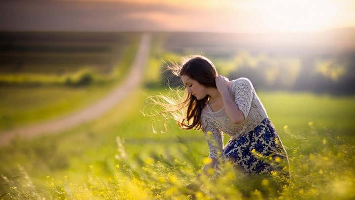Girl in a field of yellow flowers by Jake Olson