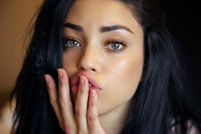 Close up portrait of a young woman with black hair and green eyes
