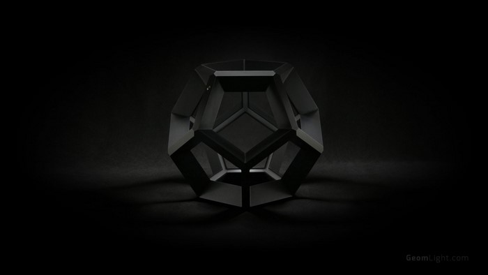 Black geometric polyhedron on a dark background