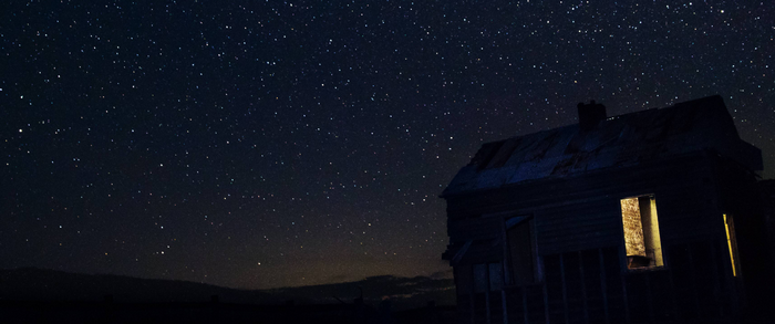 Abandoned house under a starry night sky