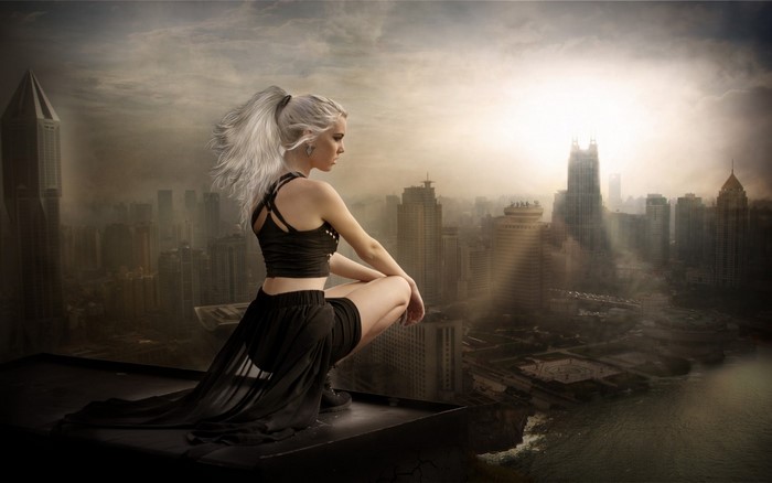 Woman in black outfit on rooftop overlooking cityscape