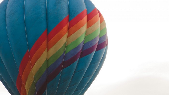 Close-up of a blue hot air balloon with rainbow stripes