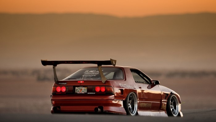 Red Mazda RX-7 with a large rear spoiler