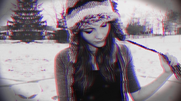 Girl in winter hat playing with her braid