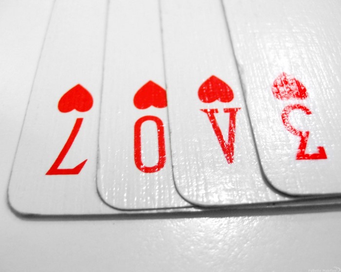 Playing cards spelling LOVE with hearts