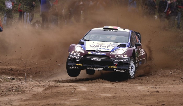 Ford Fiesta WRC rally car jumping on a dirt track