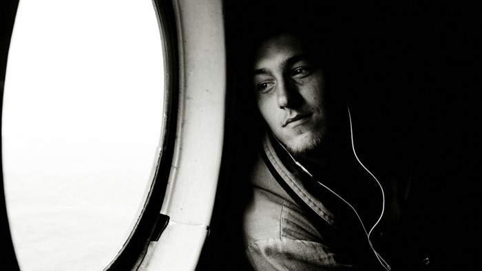Man with headphones looking out a window