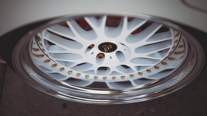 White multi-spoke alloy wheel with gold accents