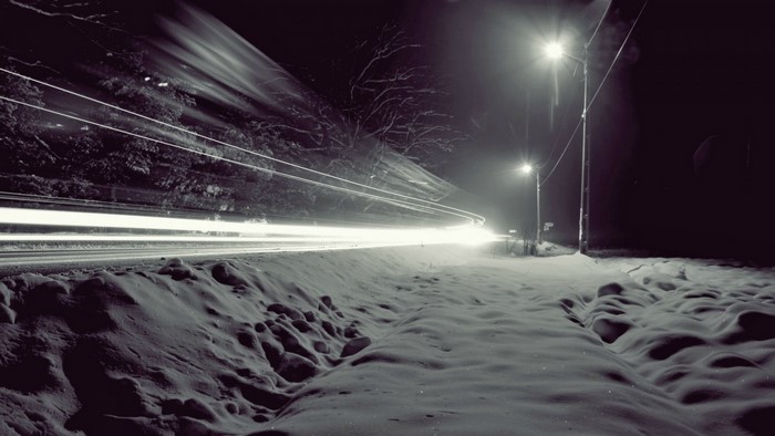 Long exposure of light trails on a snowy road at night