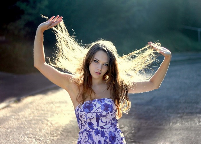 Young woman with windblown hair in a floral dress