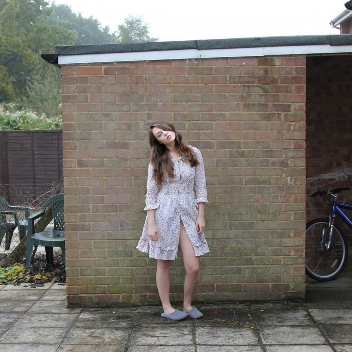 Woman in floral dress standing outside