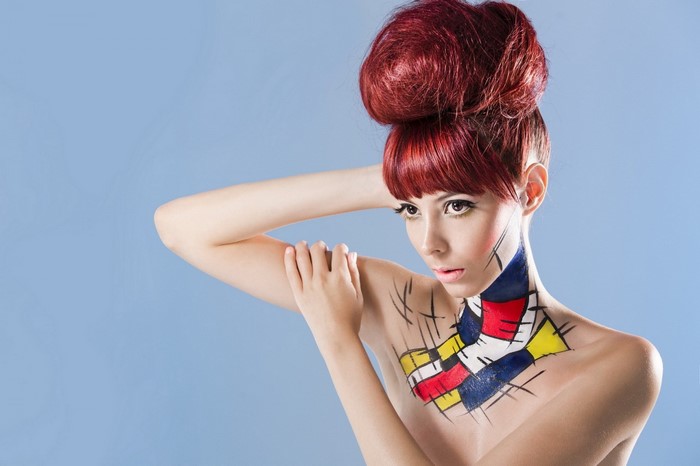 Model with abstract body paint and red updo