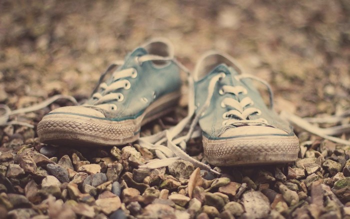 Pair of blue Converse sneakers on gravel