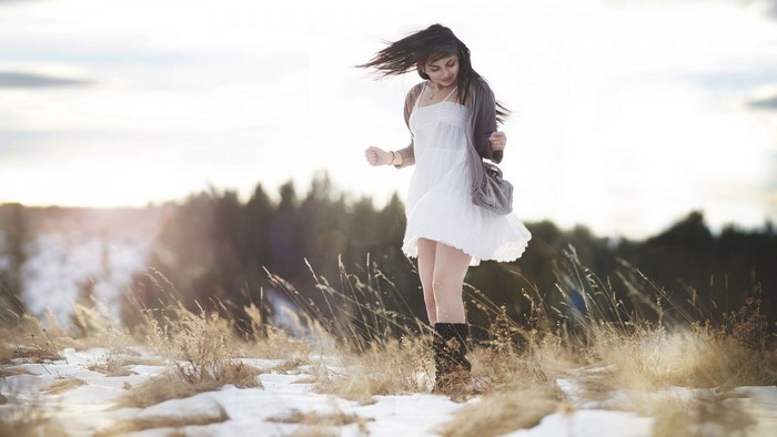 Woman in white dress in a snowy field