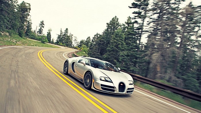 Silver Bugatti Veyron driving on a winding mountain road