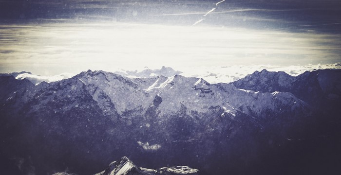 Snow-covered mountains under a bright sky