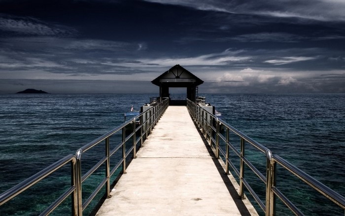 Pier with a shelter over the ocean at dusk