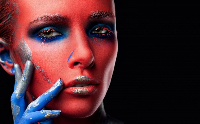 Model with red face paint and blue and silver accents