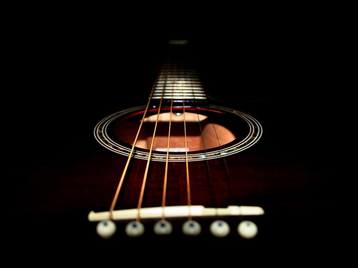 Close-up of an acoustic guitar's soundhole and strings