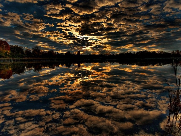 Sunset reflected on a lake with dramatic clouds