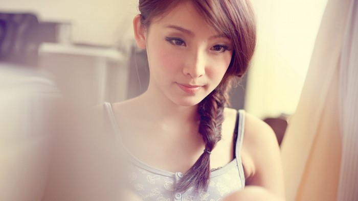 Asian woman with braided hair wearing a tank top