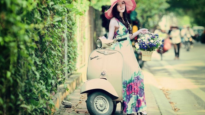 Woman in floral dress with flowers and scooter