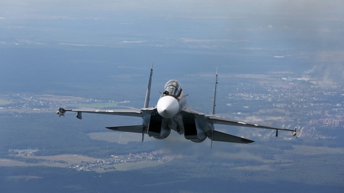 Sukhoi Su-27 fighter jet flying over landscape