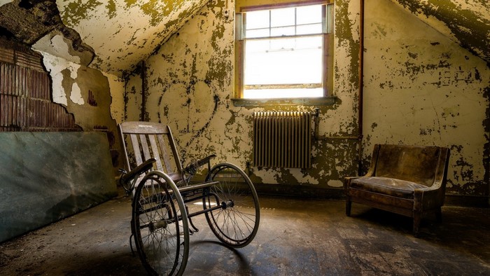 Abandoned room with wheelchair and chair