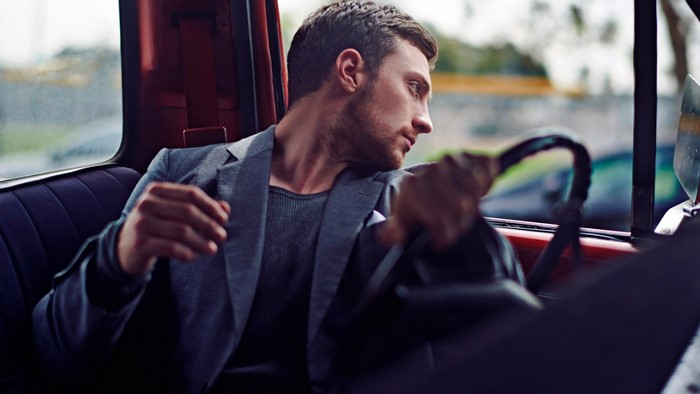 Man in suit driving a car