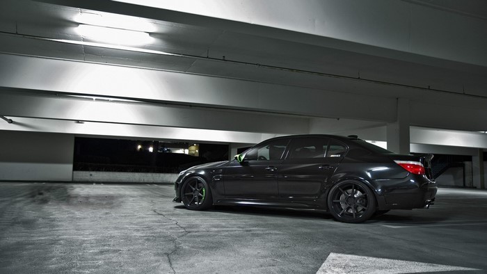 Black BMW E60 M5 sedan parked in a parking garage