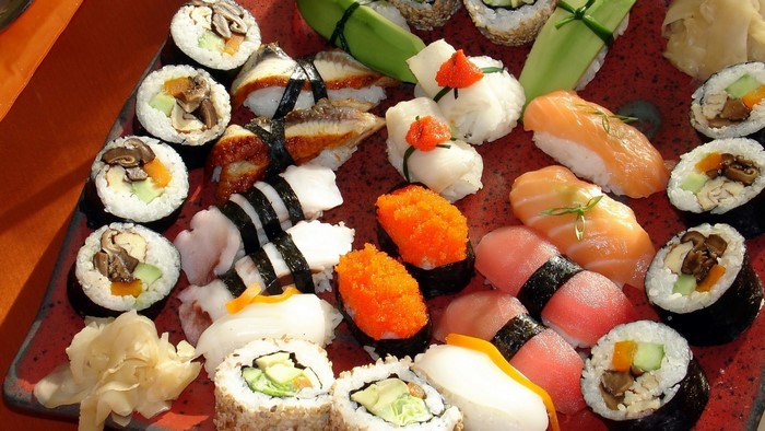 Assortment of sushi and rolls on a red platter