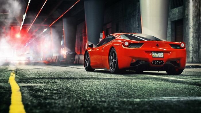 Red Ferrari 458 Italia parked on a wet street at night