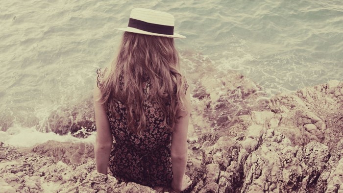 Woman in hat and dress by the sea