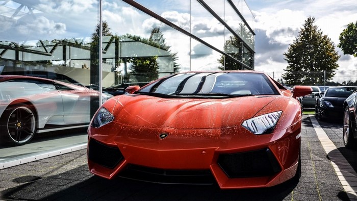 Orange Lamborghini Aventador parked outside a modern building