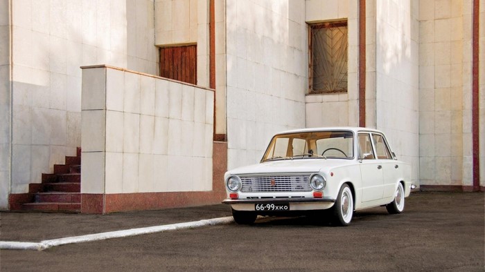 White vintage Lada car parked near a building