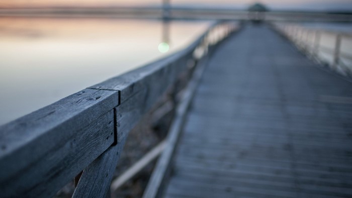 Wooden pier over water at sunrise