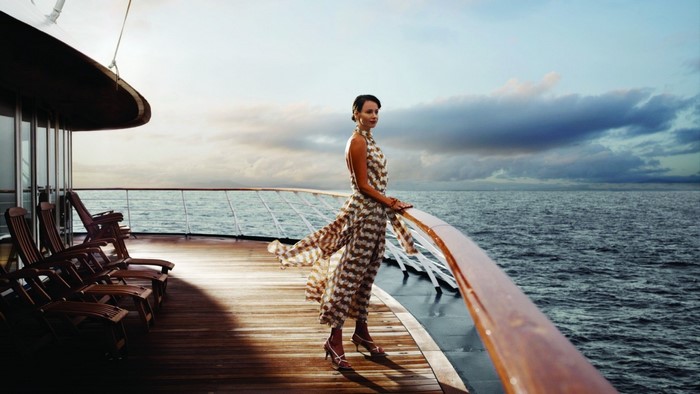 Woman in dress on a ship deck overlooking the ocean