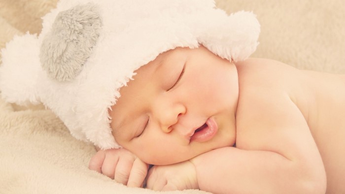 Baby sleeping in a fuzzy hat
