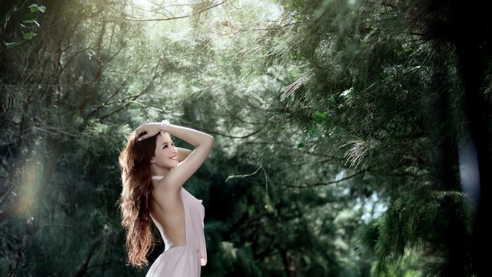 Woman in White Dress in Sunlit Forest
