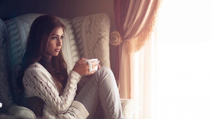 Woman holding a mug in a chair