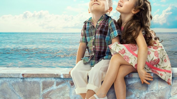 Boy and girl sitting by the sea