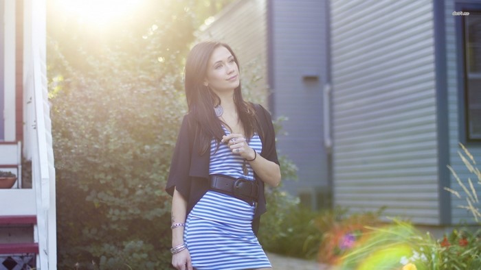 Woman in striped dress and black jacket outdoors